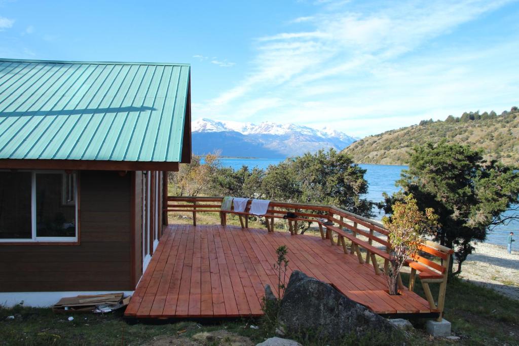 um deque de madeira com um banco ao lado de uma casa em Patagonia 47g em Aldana