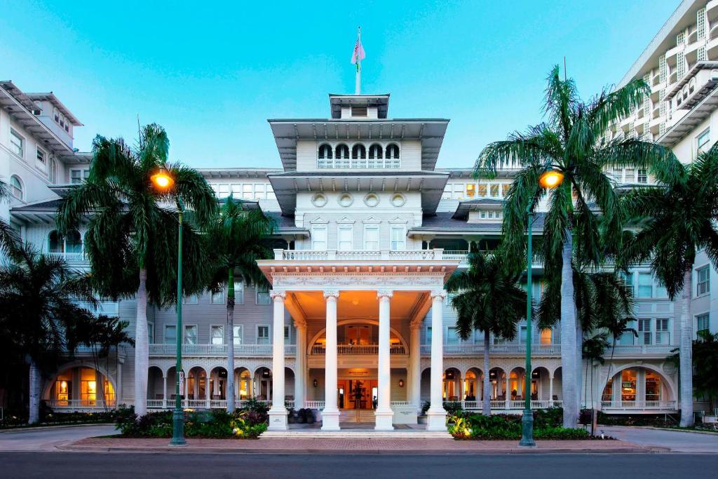 a white building with palm trees in front of it at Moana Surfrider, A Westin Resort & Spa, Waikiki Beach in Honolulu