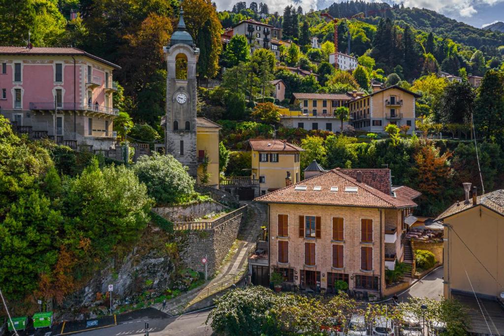 a town on a hill with a clock tower at Hotel Ristorante Vapore in Faggeto Lario 