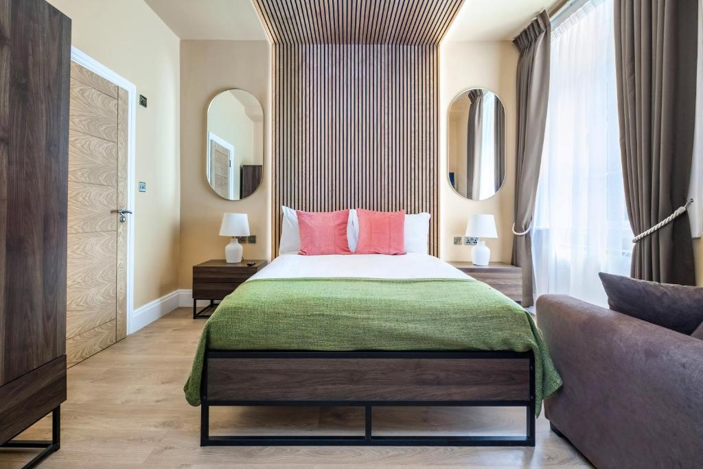- une chambre avec un lit doté d'oreillers roses et d'un canapé dans l'établissement Luxury Apartment in the heart of Central London, à Londres