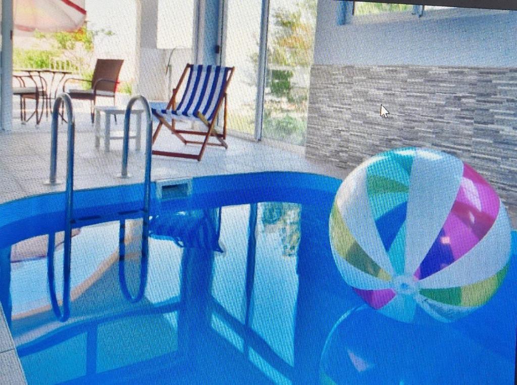 a swimming pool with a beach ball and a umbrella at DOROTEA3 in Makarska