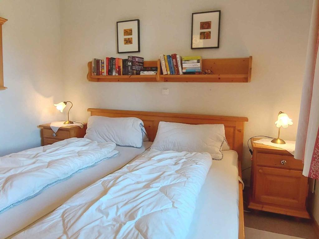 two beds in a bedroom with two lamps and books at Holiday home in Bad Mitterndorf - Steiermark 41114 in Bad Mitterndorf