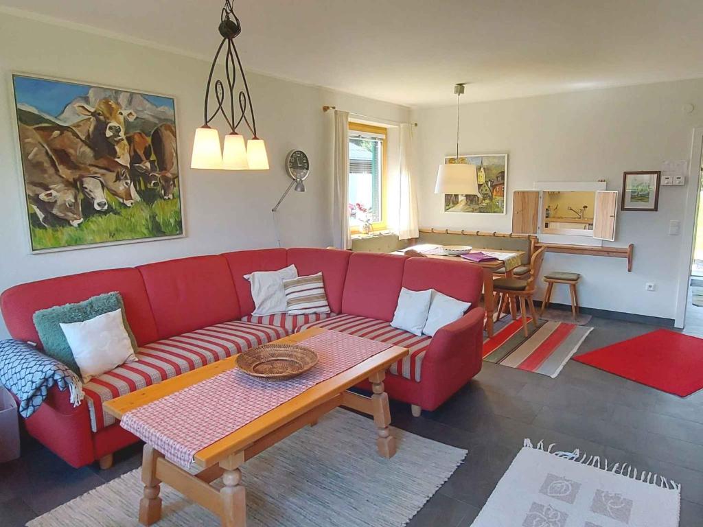 a living room with a red couch and a table at Holiday home in Bad Mitterndorf - Steiermark 41114 in Bad Mitterndorf