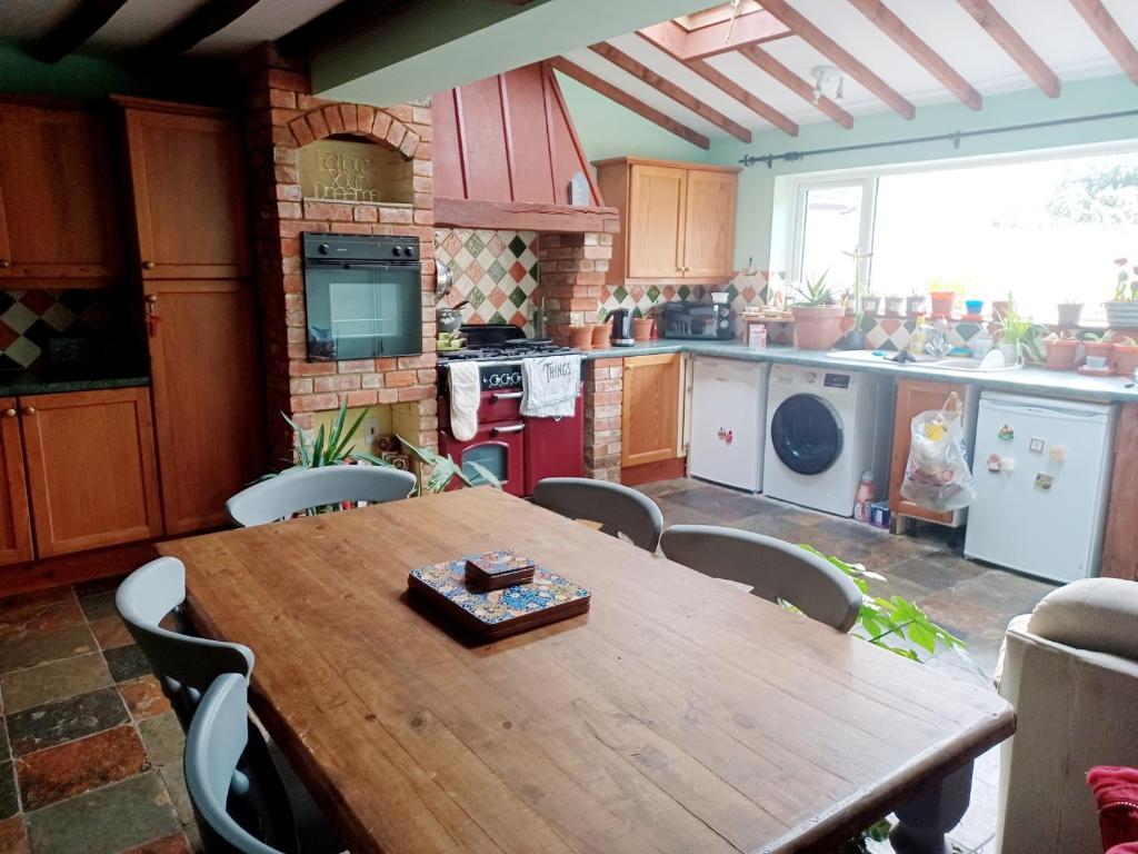 eine Küche mit einem Holztisch und Stühlen in der Unterkunft 200m AOSB Cottage in Westbury in Westbury