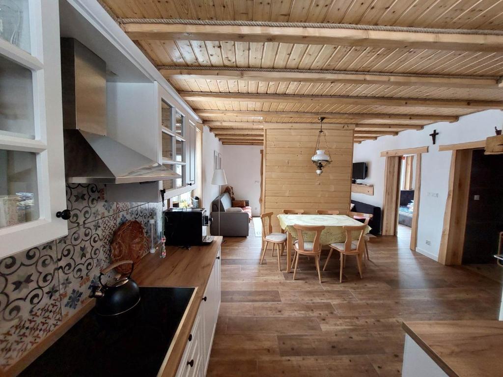 a kitchen with a table and a dining room at Domek nad Solinką in Żubracze