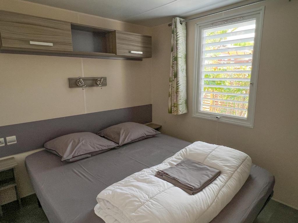 a small bedroom with a bed with a window at Sas Robrecht in Saint-Tropez