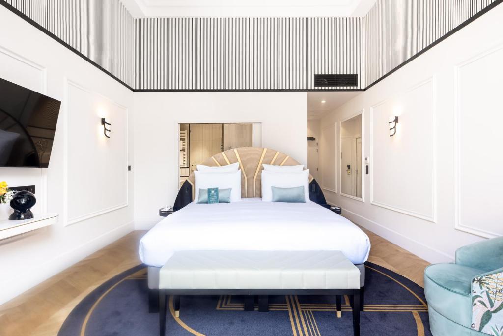 a bedroom with a bed and a couch at The 1932 Hotel & Spa Cap d'Antibes - MGallery Collection in Juan-les-Pins