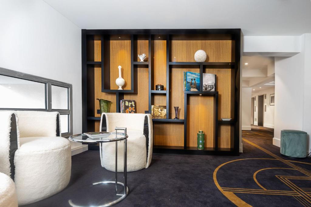 a living room with two chairs and a table at The 1932 Hotel & Spa Cap d'Antibes - MGallery Collection in Juan-les-Pins