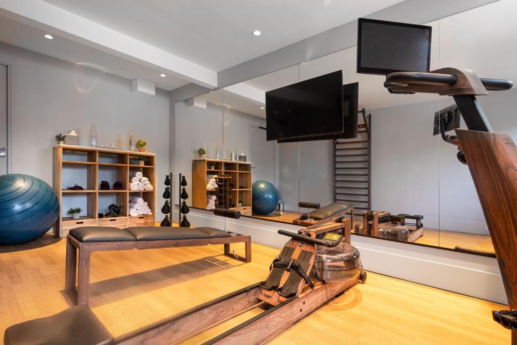 a living room with a gym with a television and a table at The 1932 Hotel & Spa Cap d'Antibes - MGallery Collection in Juan-les-Pins