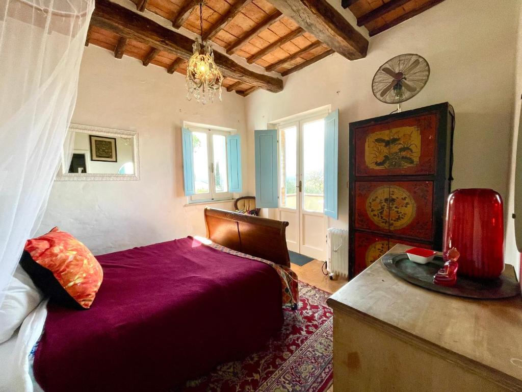 sypialnia z łóżkiem i zegarem na ścianie w obiekcie Magical villa, breathtaking views, large private garden and olive grove - in a cool village on the Umbria Tuscany Border w mieście Gioiella