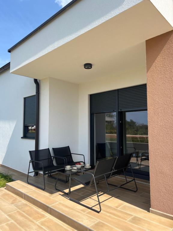 a patio with chairs and a table on a house at Modern Home Ula in Brtonigla