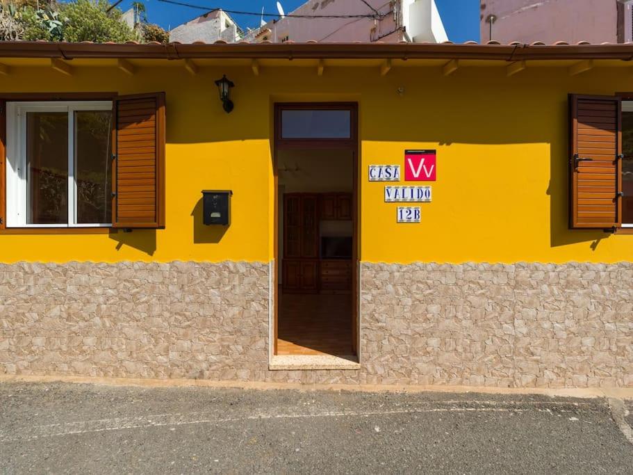 een geel gebouw met een bord aan de zijkant bij Casa Valido in Las Palmas de Gran Canaria