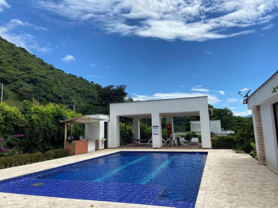 a swimming pool in front of a house at Un paraíso a 30 minutos de Medellín. in San Jerónimo