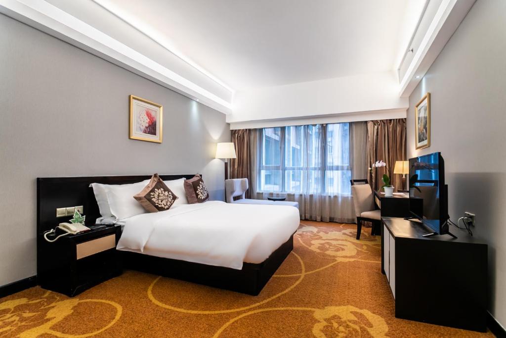 a hotel room with a large bed and a television at Landmark International Hotel in Guangzhou