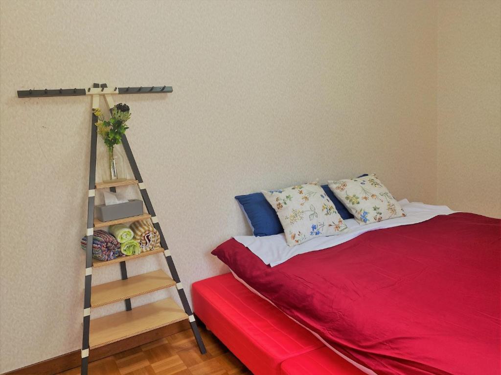 Un dormitorio con una cama roja y una escalera en Shonan no Oka no Villa - Vacation STAY 24987v, en Fujisawa