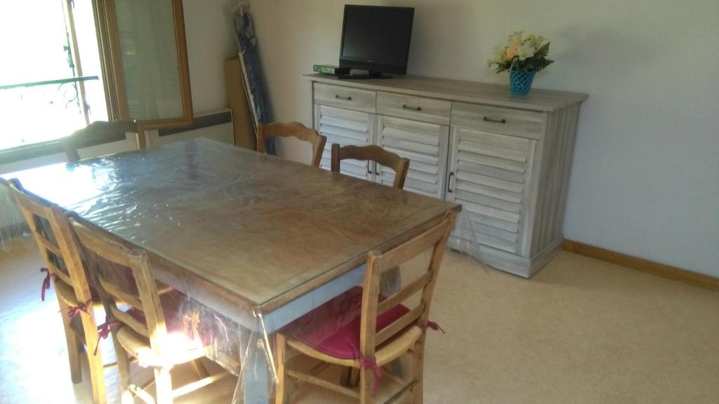 une salle à manger avec une table, des chaises et une télévision dans l'établissement Mireille, à Castellane