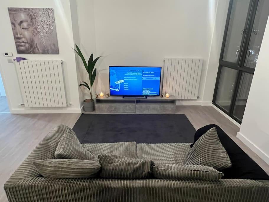 a living room with a couch and a television at East London penthouse views 2bd in Barking