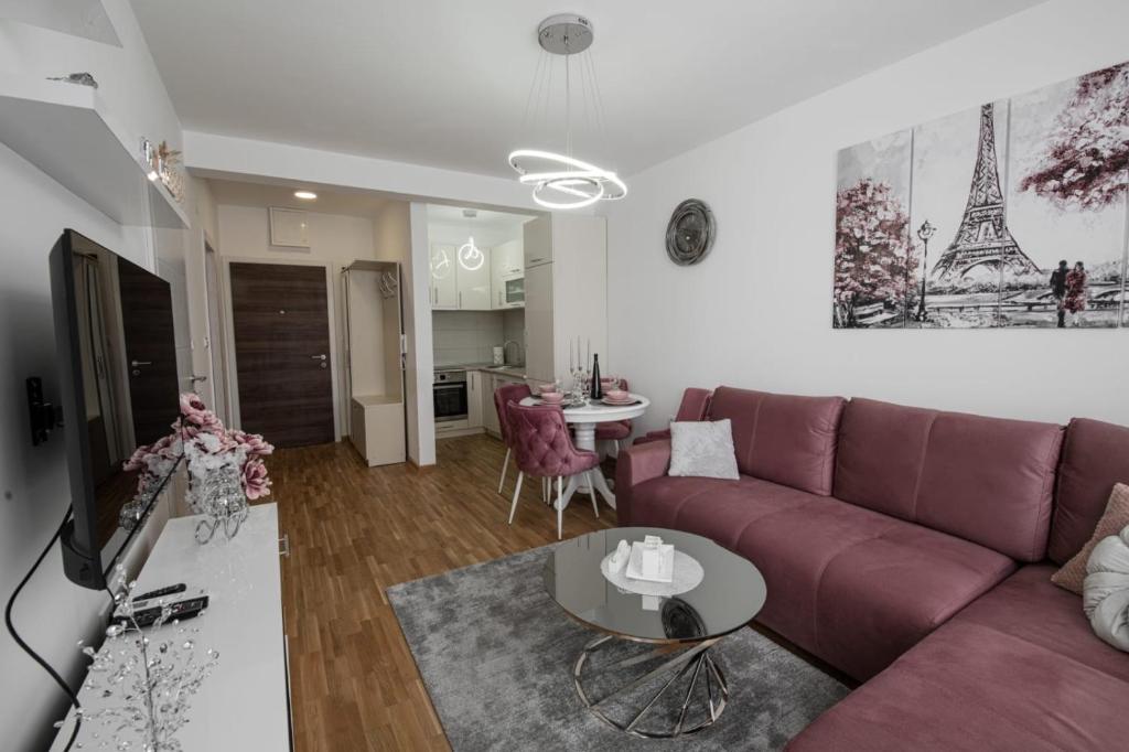 een woonkamer met een paarse bank en een tafel bij Apartman Neda N in Vrnjačka Banja