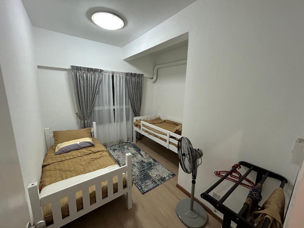 Kampong Bukit DaratにあるHanizz Vacation Homeの小さなベッドルーム(ベッド2台、ファン付)