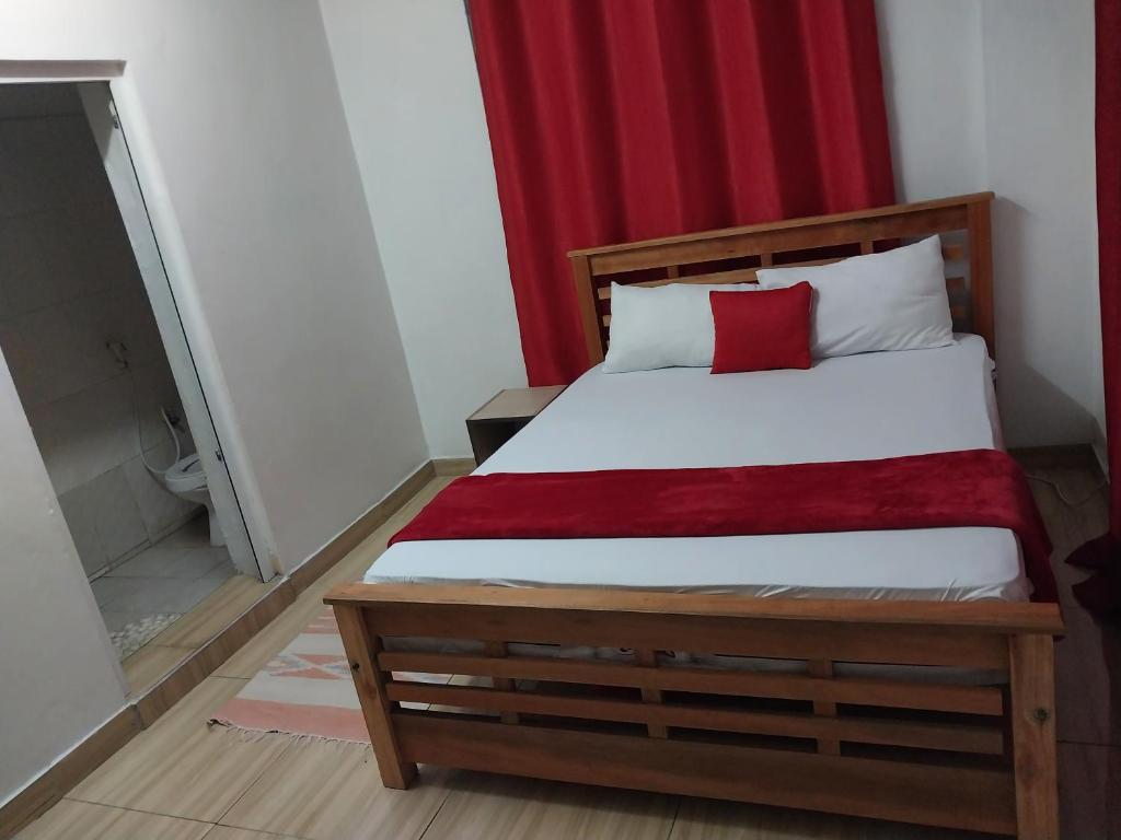 a bedroom with a bed with a red curtain at 2 spacious bedrooms in Mombasa