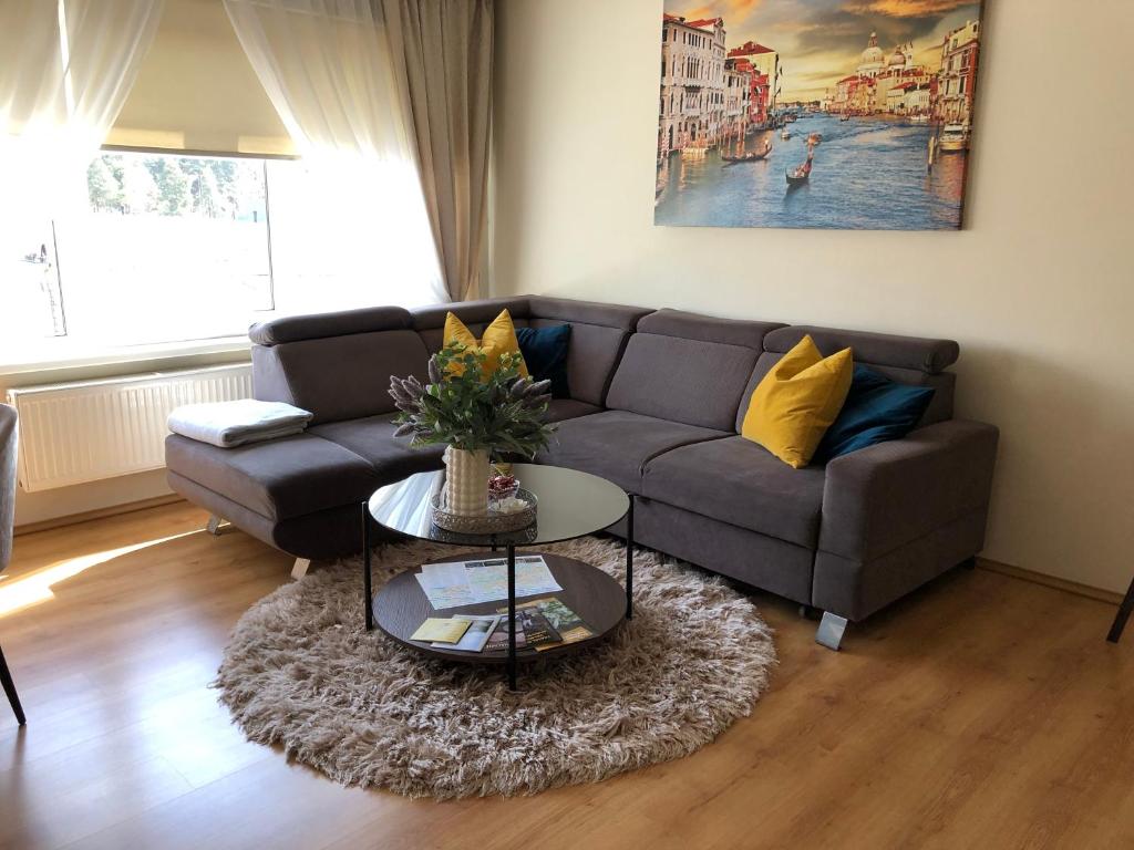 uma sala de estar com um sofá e uma mesa em Upes apartamenti Nr: 32 em Valmiera