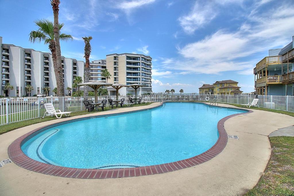 a swimming pool with tables and chairs in a resort at Bay Tree B3 in Port Aransas