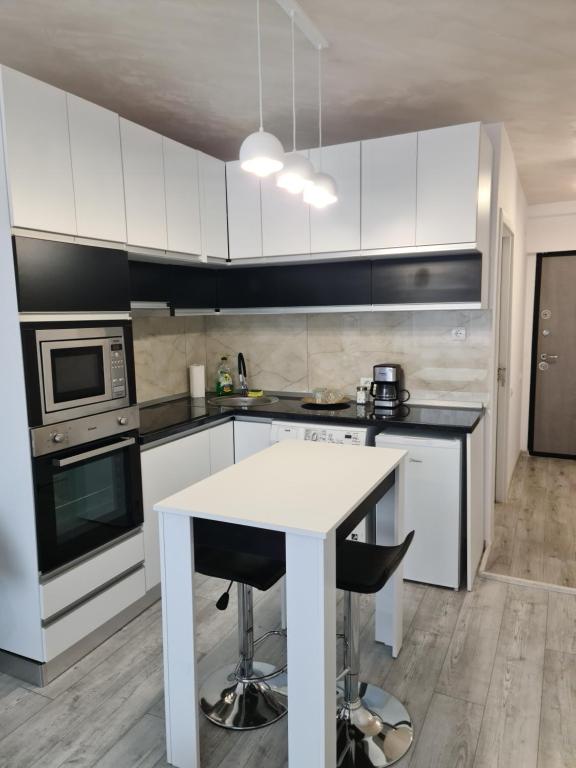 une cuisine avec des placards blancs et une table blanche dans l'établissement APARTAMENT IN CENTRU, à Oradea