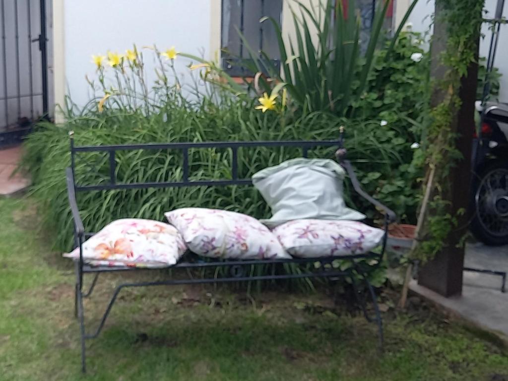 a bench with pillows on it in a yard at Los Aceres in Salta