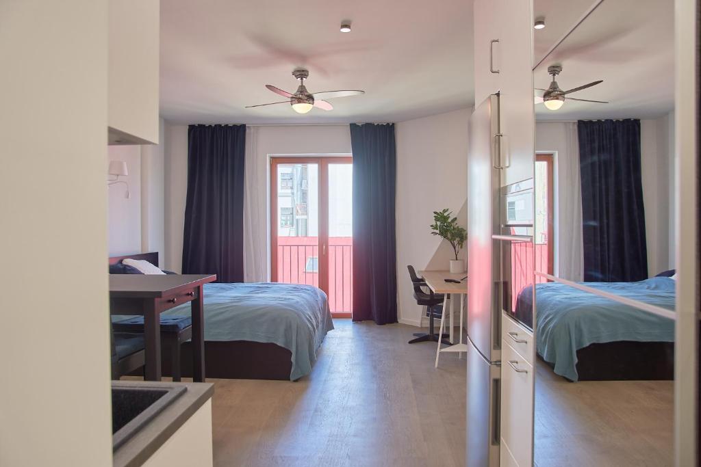 a room with two beds and a desk and a table at Studio Apartment in the Heart of Riga Old Town in Rīga