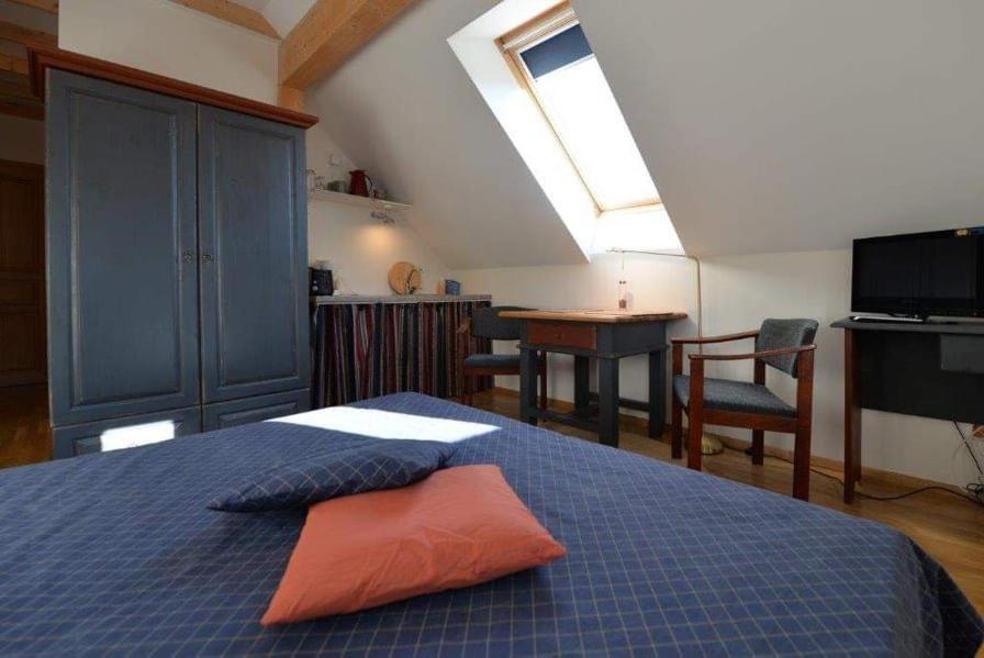 a bedroom with a bed with an orange pillow on it at Vecekrug Apartaments in Preila