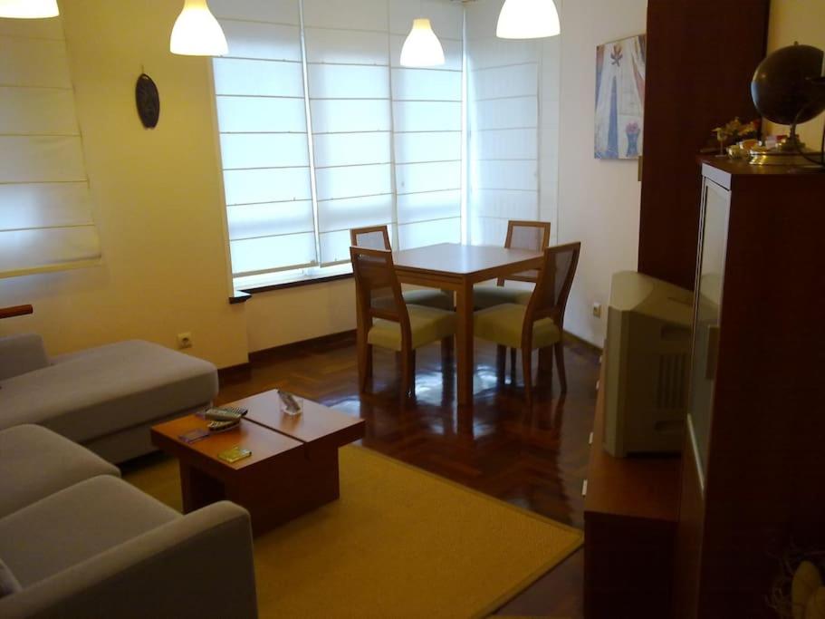 sala de estar con mesa, sillas y sofá en Piso acogedor con Parking, en Vigo
