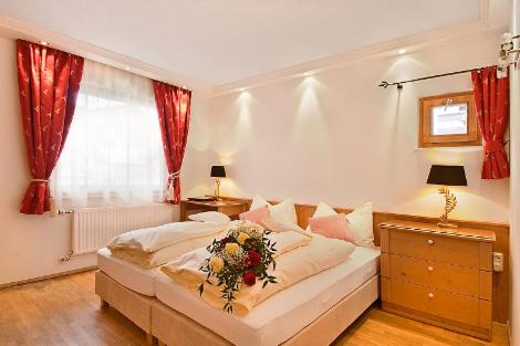a bedroom with a bed with a flower arrangement on it at Alpen Lodge in Sankt Anton am Arlberg