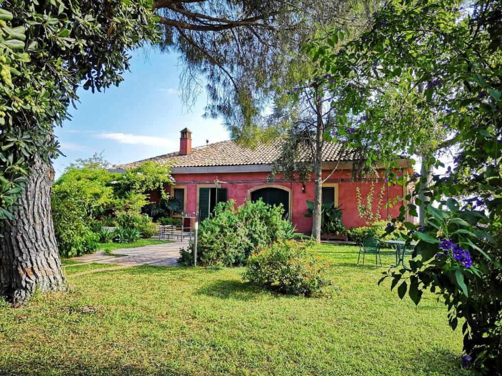 アチレアーレにあるSaja Country Houseの芝生の庭のある庭の赤い家