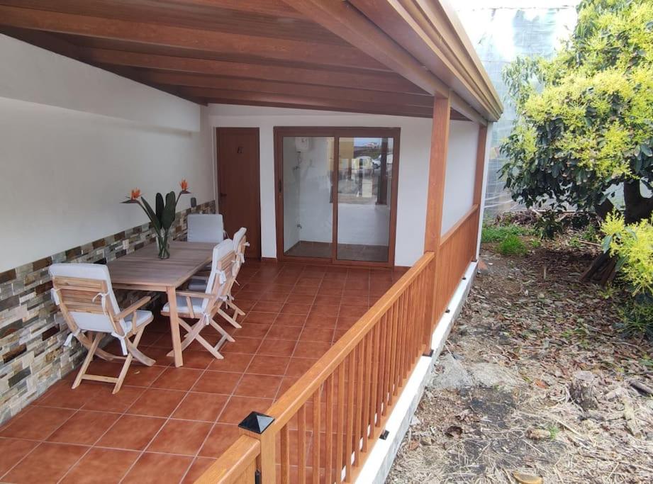 une terrasse avec une table et des chaises en bois. dans l'établissement Mercedes (E): Campo y playa., à Breña Baja