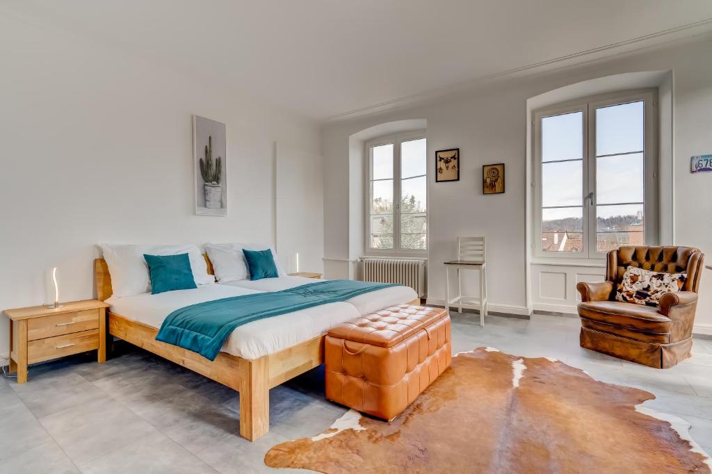 een slaapkamer met een bed en een stoel bij The 5 Continents II by Stay Swiss in Porrentruy
