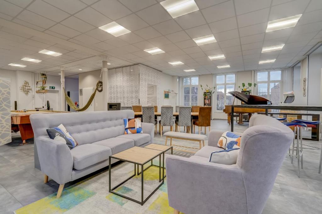 a waiting room with two couches and a piano at The 5 Continents I by Stay Swiss in Porrentruy