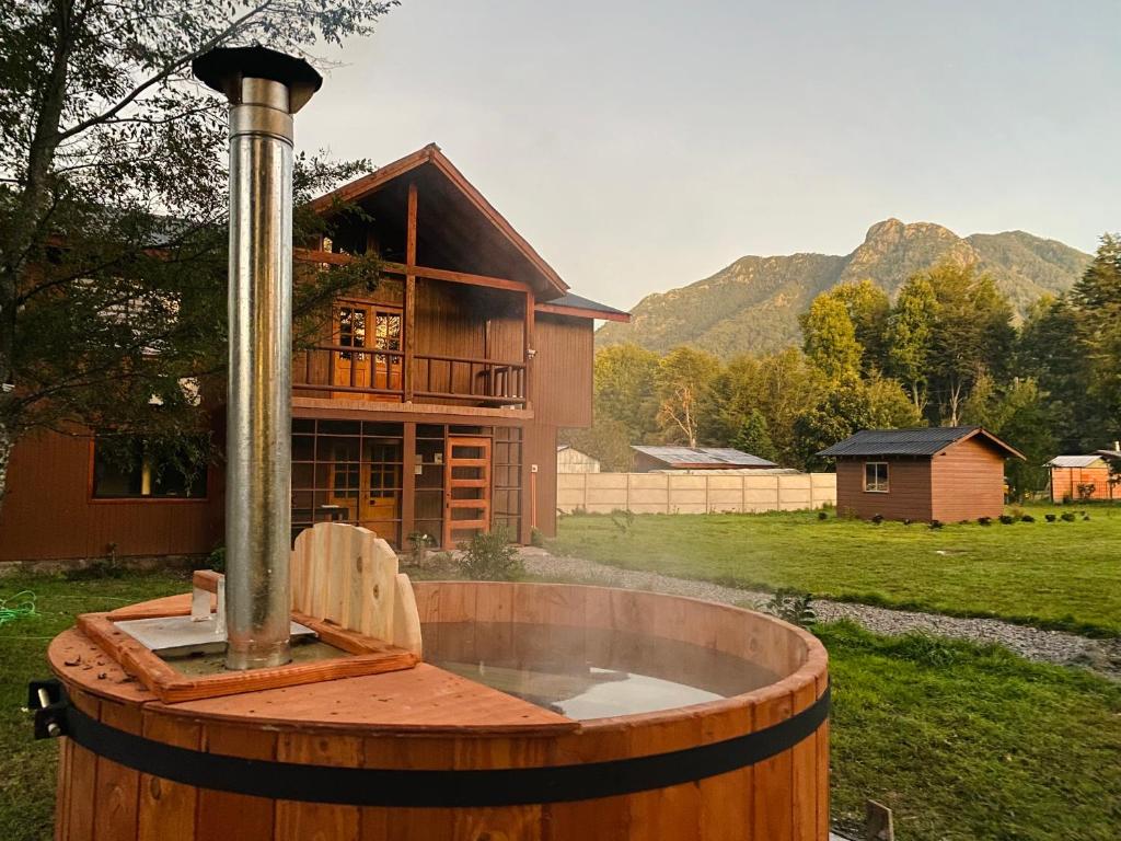 a wooden barrel with a fountain in front of a house at Hostal Treile in Pucón