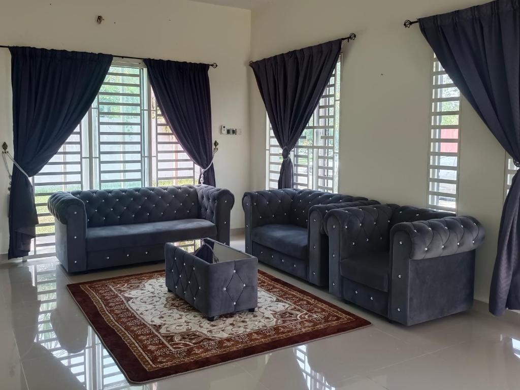 a living room with black leather couches and a table at Pro-Qaseh Room Stay , Darulaman Lake Home in Jitra