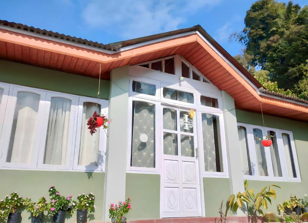 una piccola casa verde con una porta bianca di Atithi Griha Homestay - ARITAR, SILK ROUTE, SIKKIM a Aritar