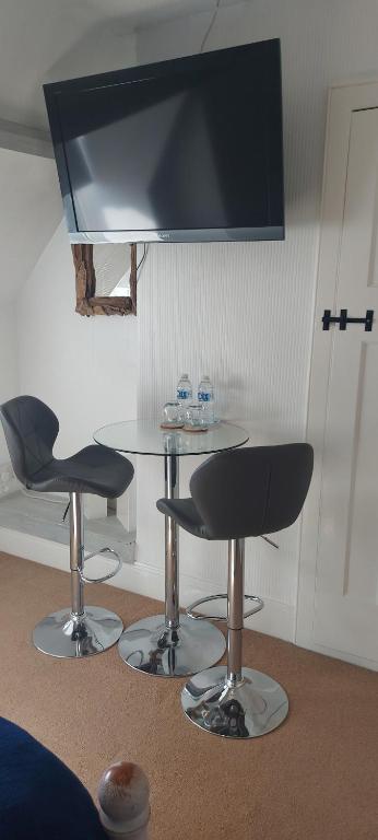 een woonkamer met een tafel en twee stoelen en een televisie bij Trentham House in Paignton