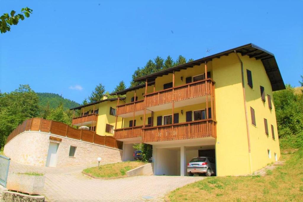 ein gelbes Gebäude mit einem davor geparkt in der Unterkunft Appartamento Girasole in Ledro