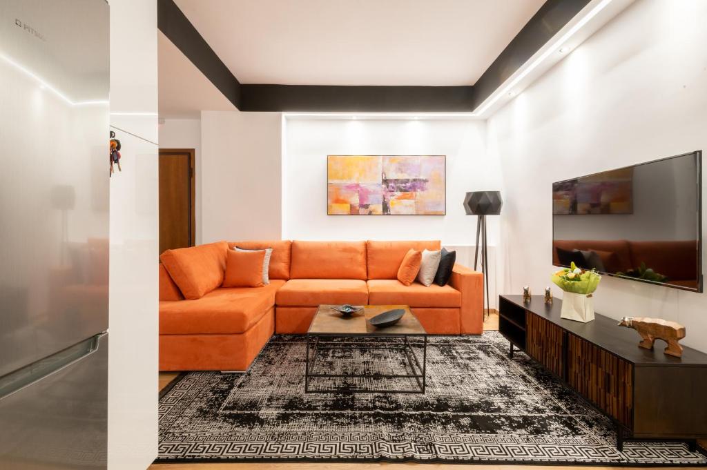 an orange couch in a living room at Acropolis Exclusive Apartment in Athens
