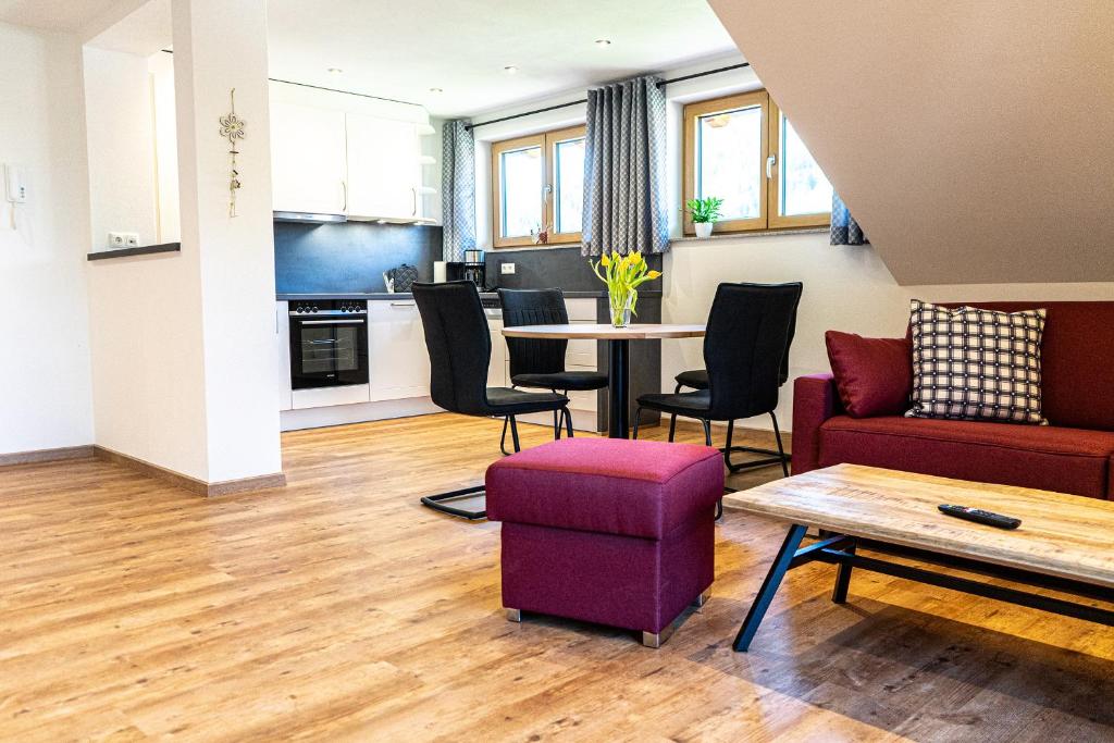 uma sala de estar com um sofá e uma mesa em Thaler Höhe em Oberstaufen