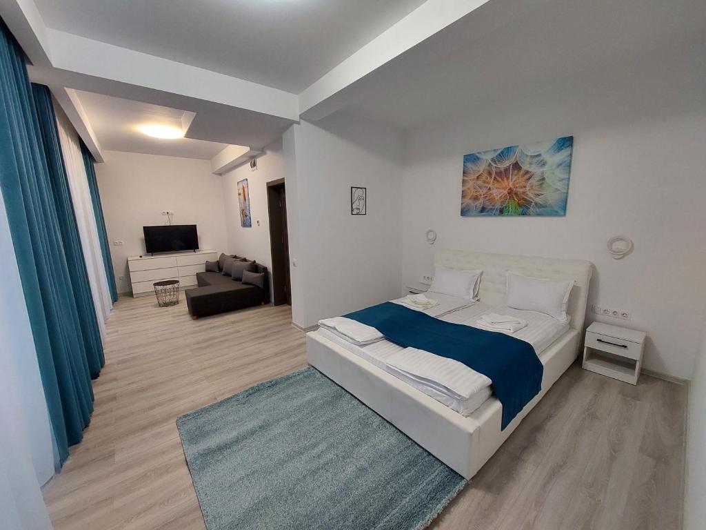 a bedroom with a bed and a living room at NoMi Ultracentral Apartments in Târgu-Mureş