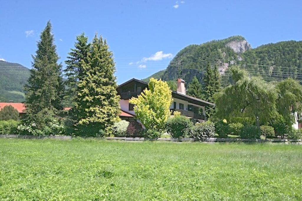 a house in the middle of a field with trees at Geräumiges Domizil mit Bergblick in Oberwössen