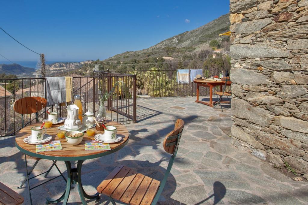 einen Tisch und Stühle auf einer Terrasse mit Aussicht in der Unterkunft Casa Poggio in Barbaggio