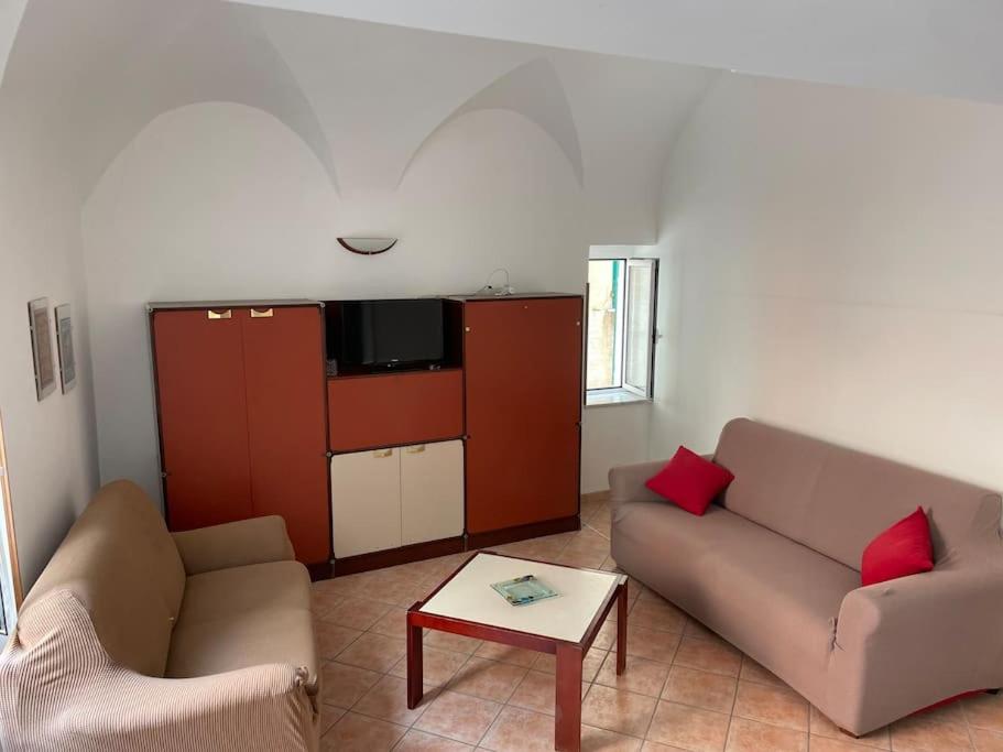 a living room with two couches and a table at Appartamento a due passi dal mare in Finale Ligure