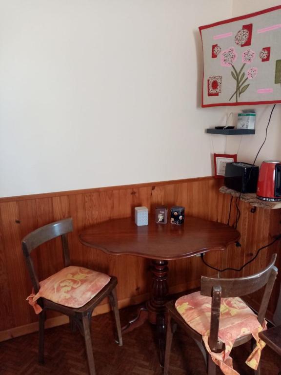 uma mesa de madeira e duas cadeiras e uma mesa e cadeiras em Chambre Rdc em Saint-Aubin-le-Monial