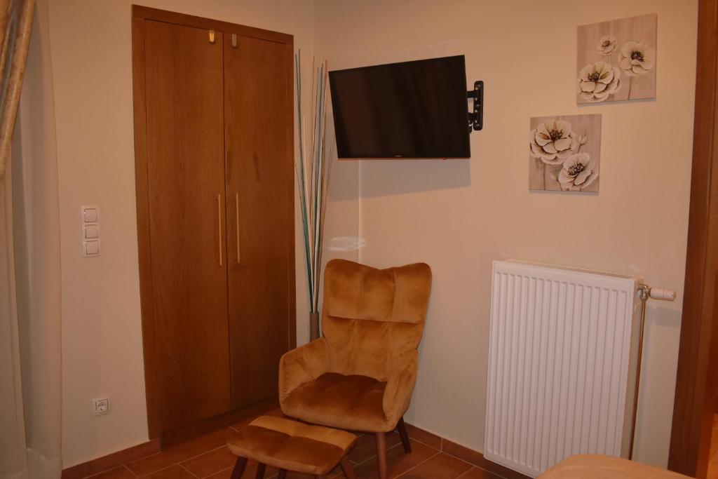 a living room with a chair and a flat screen tv at Harmony 2 in Gold in Lávrion