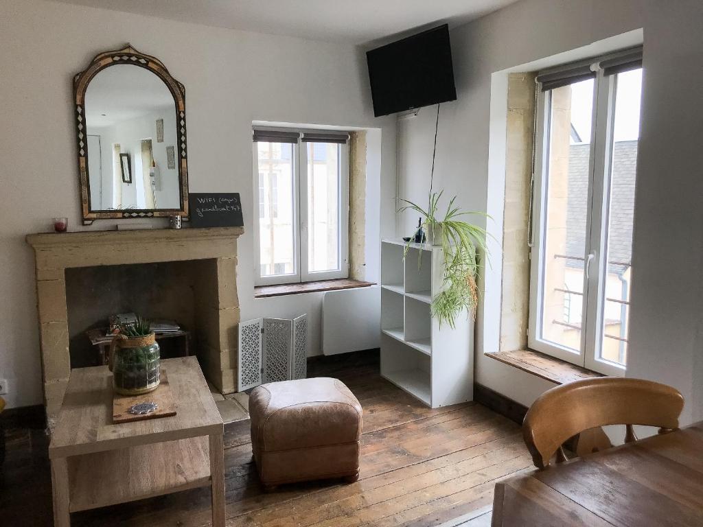 ein Wohnzimmer mit einem Tisch und einem Spiegel in der Unterkunft Idha à proximité de Bayeux in Vaucelles